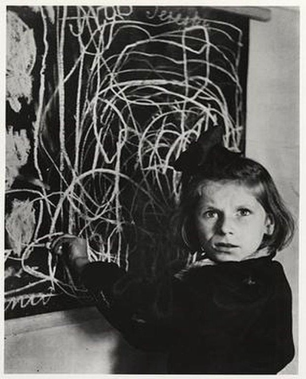 Ośmioletnia dziewczynka rysuje dom. Ocalała z rzezi Woli, całe życie zmagała się z cierpieniem i chorobą, Warszawa 1948 (fot. David Seymour, Magnum Photos; prawa zastrzeżone)